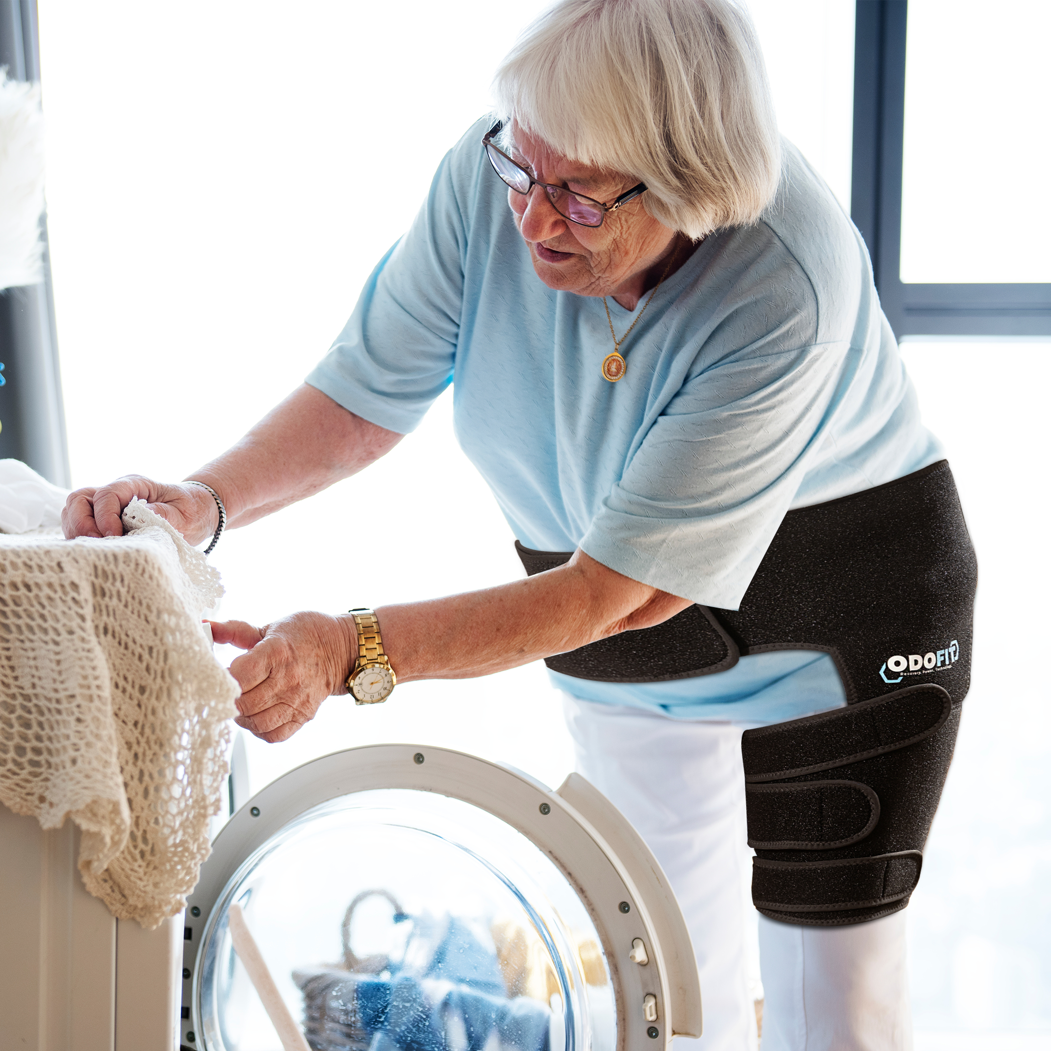 Older woman wearing the ODOFIT hip brace doing laundry at home