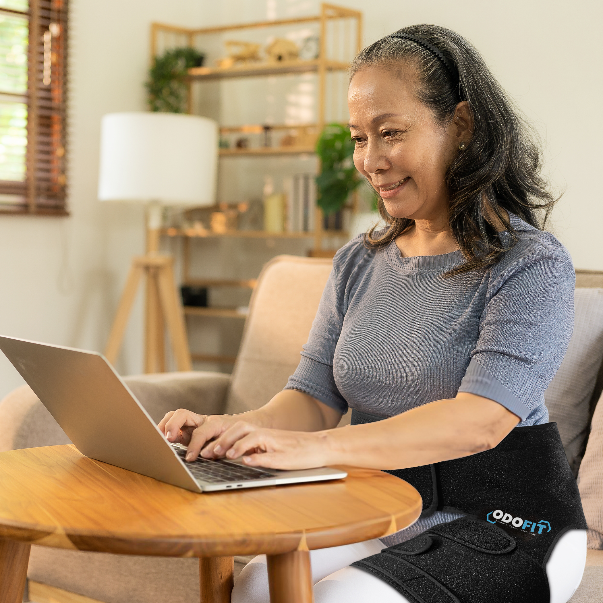 Woman wearing the ODOFIT hip brace working comfortably at a laptop